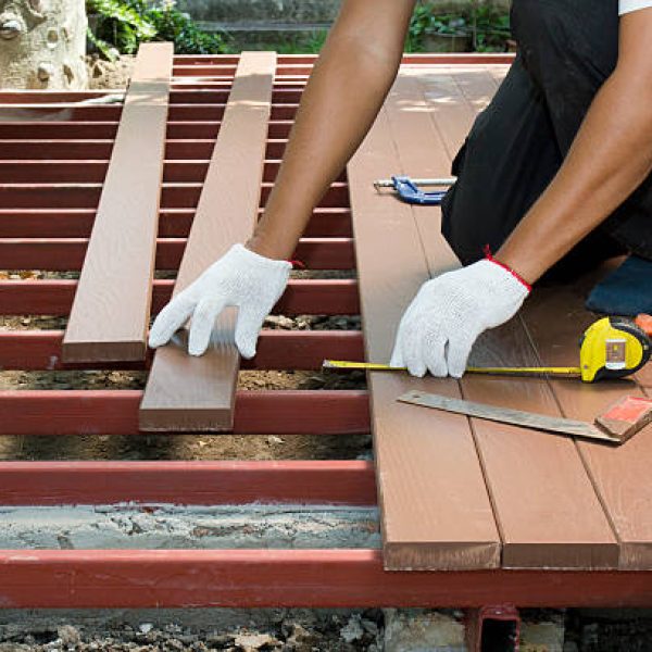 Worker installing wood floor for patio